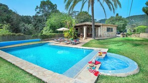 Ein Schwimmbecken mit Liegestühlen und einem Haus mit Terrasse.