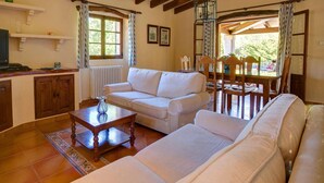 Ein gemütliches Wohnzimmer mit einer Couch, einem Couchtisch und einem Essbereich mit Stühlen und Tisch.