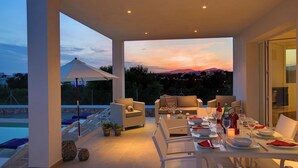 A modern outdoor dining area with a pool, lounge chairs, and a scenic sunset view. - Modern Stylish Villa, A/C, Private Pool, Marina Views, 10mins walk to Cala d'Or & 2 Sandy Beaches! (Cala d´Or)