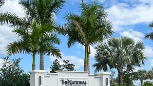 Un edificio bianco con un cartello che indica "The National Golf & Country Club" ad Ave Maria, in Florida.