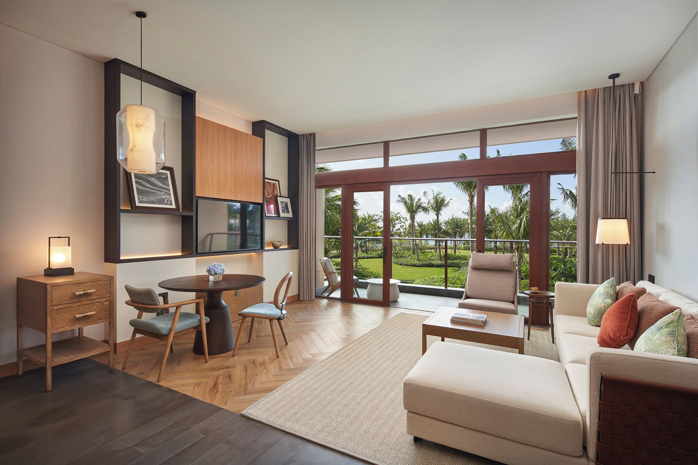 A modern living room with a dining area, large windows, and a view of the outdoors.