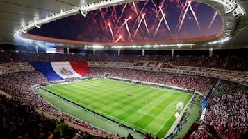 A large stadium with a football field, surrounded by a crowd of spectators.