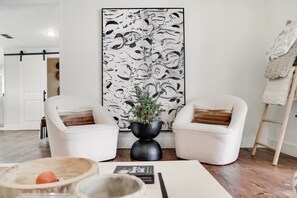 Relax in this stylish living room with two armchairs, a side table, and a potted plant.