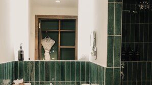A bathroom with a large mirror, two sinks, a robe, and toiletries. - Le Val Thorens (Les Belleville)