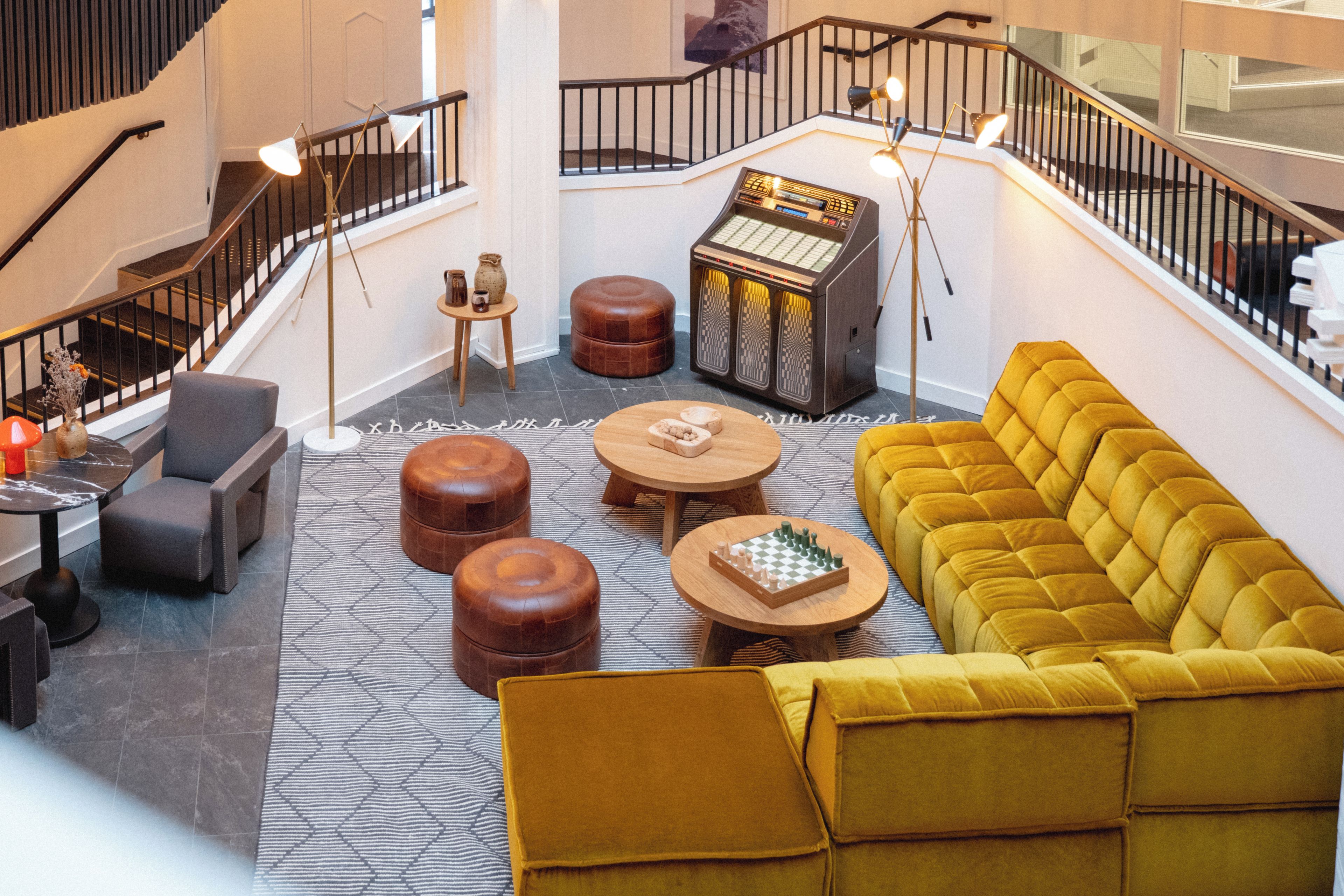 Un vestíbulo amplio con escaleras, un área de descanso y un jukebox.