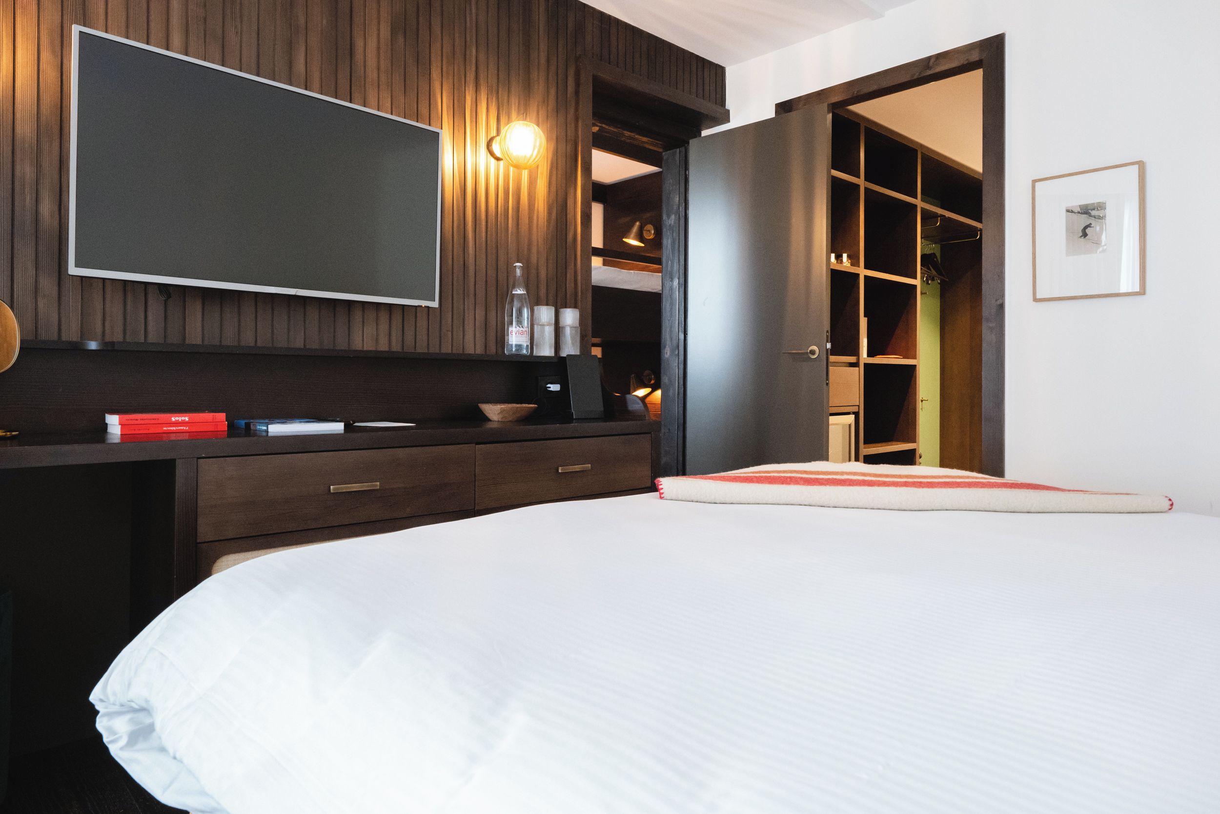 Un dormitorio con cama, cómoda, espejo y armario.