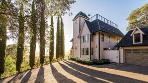 A modern two-story house with a garage, surrounded by tall trees and a driveway. - Yount Ridge Estate, Yountville CA (Napa)