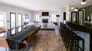 A spacious kitchen with a large island, modern bar area, and a fireplace. - Yount Ridge Estate, Yountville CA (Napa)