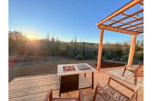Relax by the fire pit in a serene outdoor setting surrounded by lush vegetation.