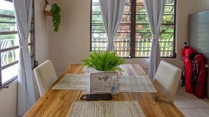 A dining table with a sign indicating wifi availability, surrounded by chairs and a potted plant. - A Slice of the Rainforest! Near El Yunque and Beaches, Rio Grande Puerto Rico (Rio Grande)