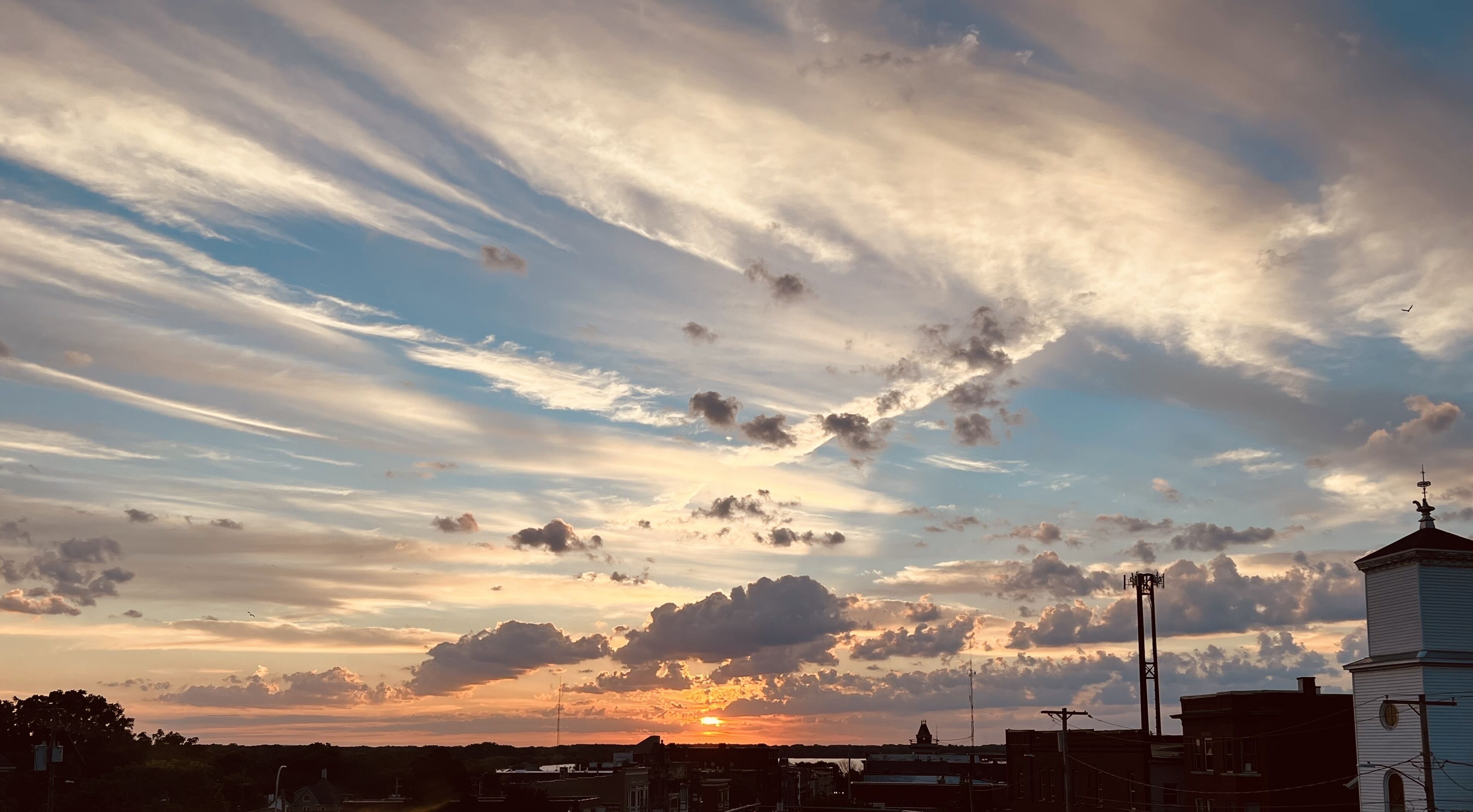 Un atardecer con nubes sobre un paisaje urbano.
