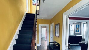 A staircase with black steps and a wooden handrail, leading to a landing with a patterned rug. - Spacious ‘GEM’ of the city (Geneva)