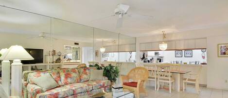 A living room with a sofa, coffee table, and a dining area with chairs and a table.