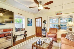 Cozy living room with a traditional aesthetic, featuring a sofa, armchairs, and a bookshelf.