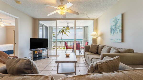 A hotel room with a balcony, a TV, a sofa, and a dining table. - Brisa Del Mar by Avantstay Communal Pool Gated Community Ocean Front (Key West)