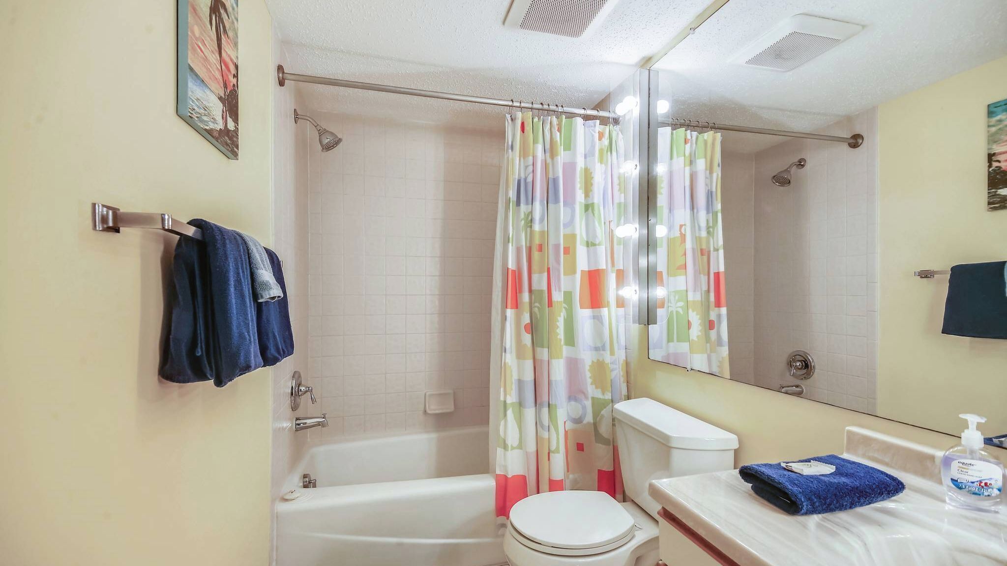 A bathroom with a bathtub, toilet, and a shower curtain.