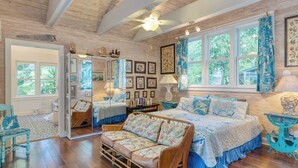 A bedroom with a large bed, a sofa, a chest of drawers, and a window with curtains. - Boat House by Avantstay Character Cottage Central Location w/ Shared Pool Month Long Stays (Key West)