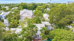 A residential area with houses, a swimming pool, and lush greenery. - Boat House by Avantstay Character Cottage Central Location w/ Shared Pool Month Long Stays (Key West)