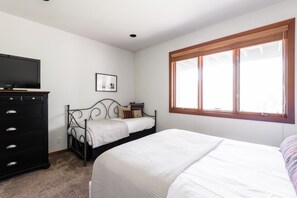 A bedroom with a bed, a dresser, a television, a window, and a framed picture on the wall. - Scarlett by Avantstay Spacious Mountain Home w/ Gorgeous Views & Hot Tub (Park City)