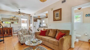A living room with a sofa, armchair, coffee table, and a ceiling fan. - Land Of Love by Avantstay Pets Allowed! Shared Pool! Great Location! Month Long Stays Only (Key West)