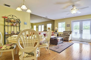A living room with a dining table, chairs, a sofa, a ceiling fan, and a large mirror. - Duval Breeze by Avantstay Great Location Close to Beach & Nightlife Shared Pool! Week Long Stays (Key West)