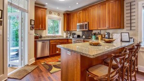 A kitchen with wooden cabinets, a granite countertop, and a built-in microwave. - Ecco Domani by Avantstay Gorgeous Home w/ Pool, Balcony in Great Location Month Long Stays Only (Key West)