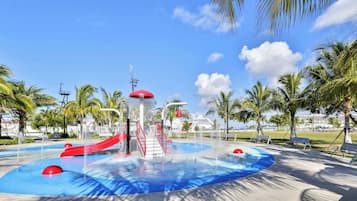 A water park with slides, a central water feature, and palm trees.