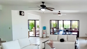 A modern living room with a white sofa, a black coffee table, and a ceiling fan. - Sosua Ocean Village New Remodeled Villa. (Sosúa)