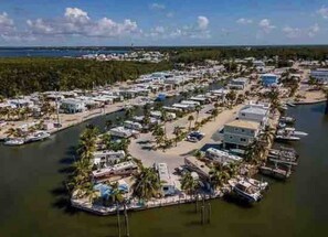 An aerial view of a marina with numerous boats docked, surrounded by a dense forest and a clear sky. - Beautiful home in Calusa, Key Largo (Key Largo)