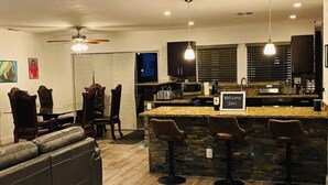 A modern kitchen with a bar area, a dining set, and a living room with a sofa. - Fun House !¡ Come to Relax or Have Fun ☀️ (Sunrise)