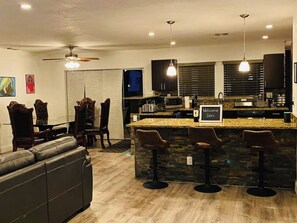 Enjoy meals and relaxation in this stylish kitchen and dining area, featuring a central island with bar stools and comfortable seating.