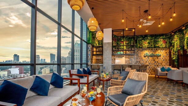 A rooftop bar with wicker furniture, a bar counter, and a city view. - Santa Grand Signature Kuala Lumpur (Kuala Lumpur)