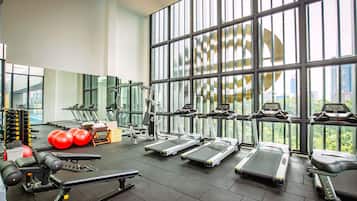 A gym with treadmills, elliptical machines, and free weights.