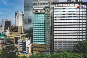 Uma paisagem urbana moderna com arranha-céus, incluindo um edifício com um logotipo amarelo e outro com um logotipo vermelho.