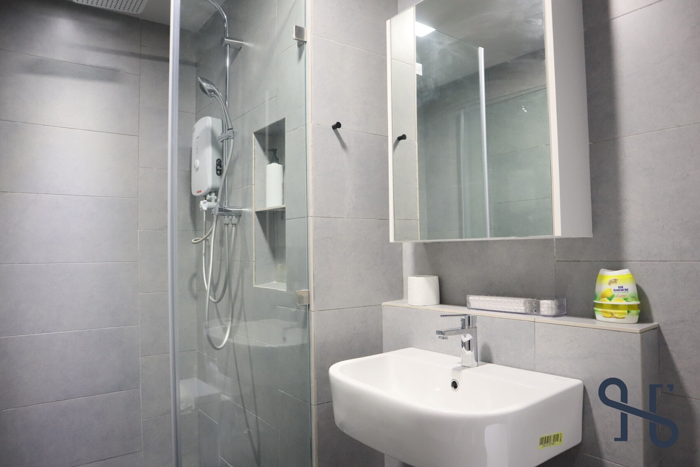 Une salle de bain moderne avec une douche à parois de verre, un lavabo blanc et un miroir au-dessus.
