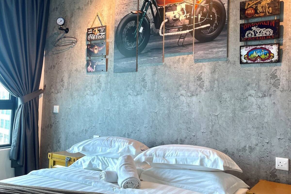 Une chambre à coucher avec un lit, une horloge murale et des décorations sur le thème de la moto.