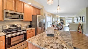 A modern kitchen with stainless steel appliances, wooden cabinets, and a granite countertop. - Scenic Views! Ski-In/Ski-Out Condo in Beech Mtn (Beech Mountain)