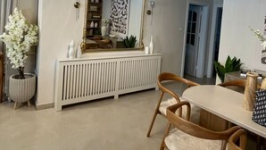 A dining area with a chandelier, a large mirror, and a white radiator.