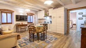 Una sala de estar acogedora con un sofá, una mesa de comedor con sillas y un televisor.