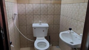 A small, tiled bathroom with a toilet, bidet, and sink. - 1 Bed Villa - Sleeps 2 - Pool - Smoking - Parking (Diani Beach kenya)