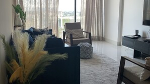 Una sala moderna con un sofá, un sillón, una mesa de centro y un televisor.