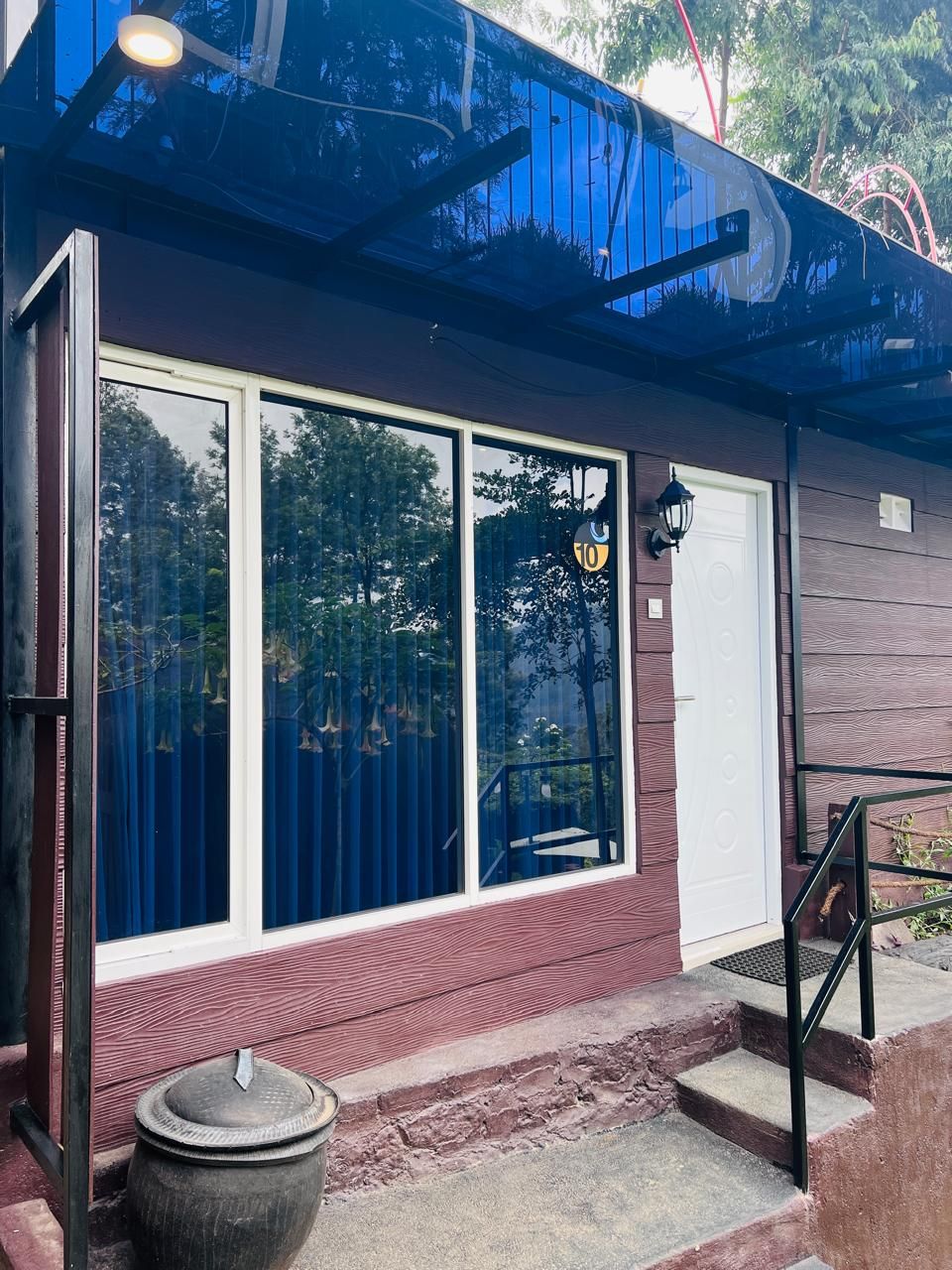 A building with large windows, a white door, and a small outdoor area with steps.