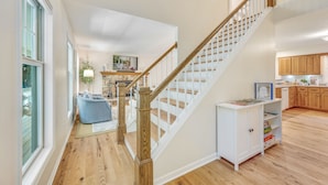 A spacious living area with a wooden staircase, a blue bean bag chair, and a white cabinet with storage shelves. - Hot Tub, Family Friendly + 2 King Beds, Game Room, Secluded -Close to SB & Beach (Ellison Bay)