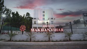 Hotel "Hotel Makhanyiar", met een moderne gevel, een hekpoort en een verzorgde tuin.