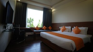 Een hotelkamer met een bed, een bureau en een raam met gordijnen.