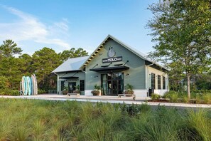 A building with a sign reading "Yolo Bike" and a row of surfboards outside. - CasaDelMar-2BR/2BA+Golf Cart-3 min to 30A Beaches! (Santa Rosa Beach)