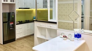Una cocina moderna con armarios blancos, un refrigerador negro y una encimera amarilla.
