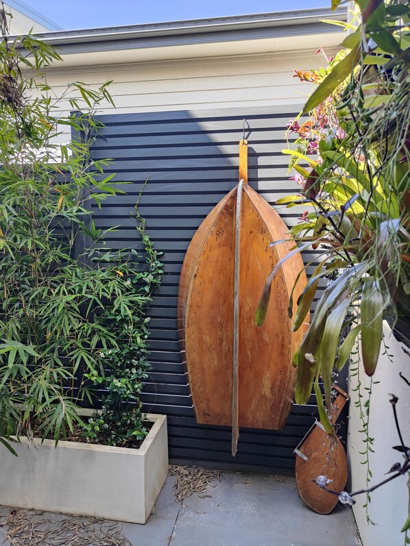 A garden area with a wooden boat, bamboo plants, and a planter box.
