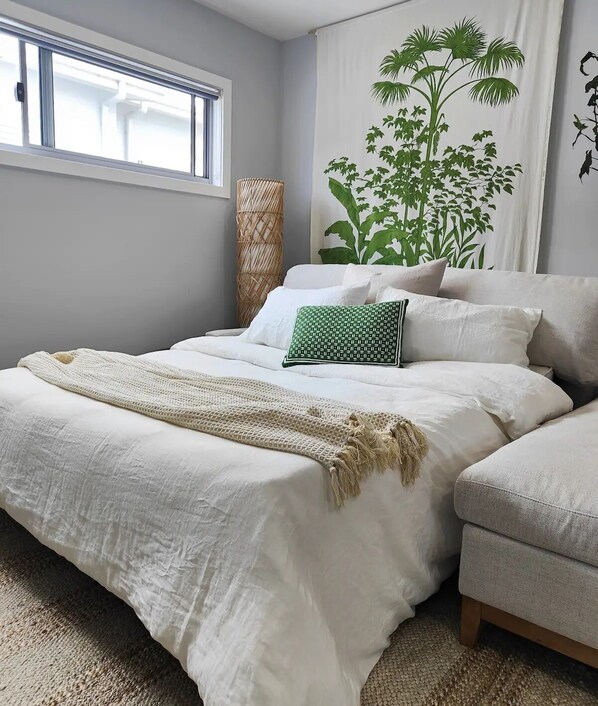 A bedroom with a bed, a chair, a large window, and a wall mural. - The Boathouse/ Luxury Home/4mins walk Marina/Shops (Shell Cove)