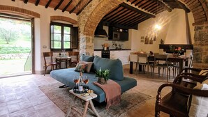 A cozy living room with a sofa, dining area, and kitchen. - Exclusive Tuscan Winery Escape: Charming Villa with Pool & Breathtaking Views. (Radda in Chianti)